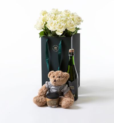 Hvite roser i gavepose med bamse gutt